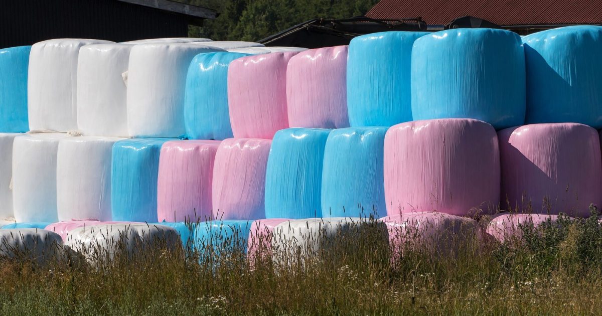 Staplade inplastade balar i vitt, blått och rosa på nära håll